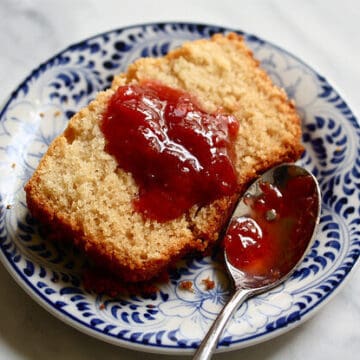 A slice of tea cake topped with strawberry jam.