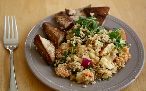 Fried tofu is served with quinoa salad with apples.