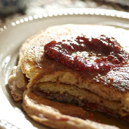 A plate of pancakes topped with jam.
