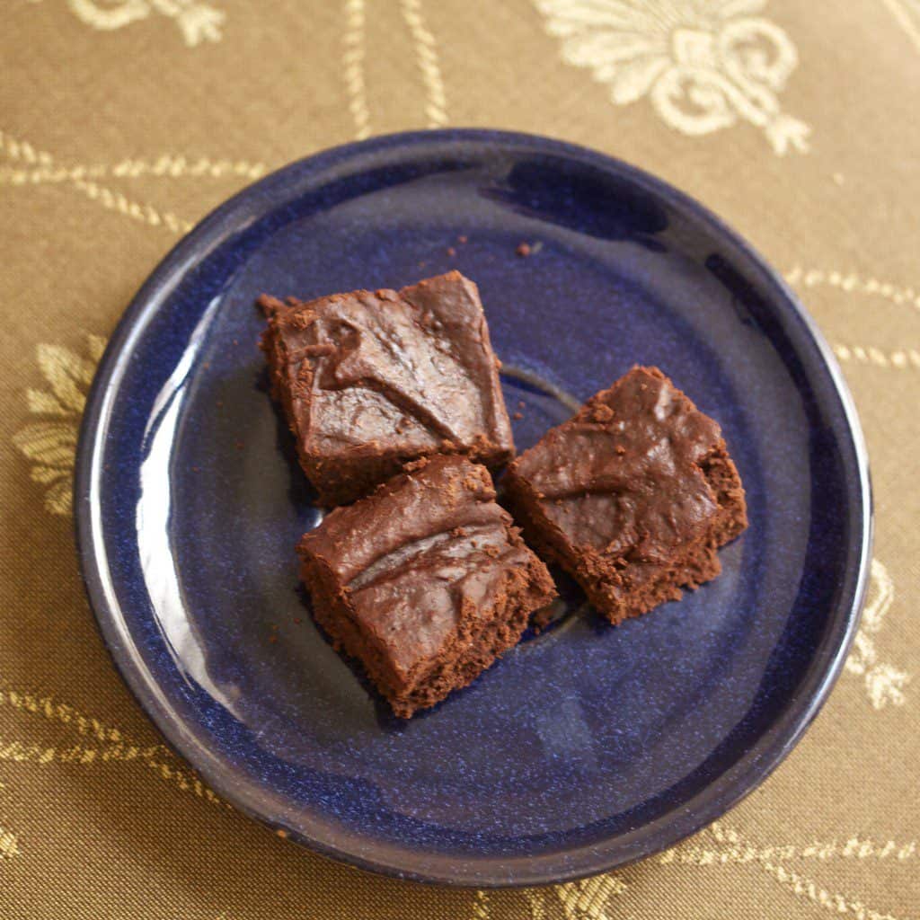 Brownies with almond butter are served on a blue plate/
