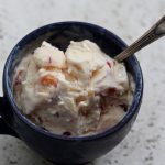 A cup of frozen yogurt with a spoon.