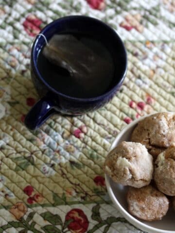 A bowl of ghriba cookies and a cup of tea.