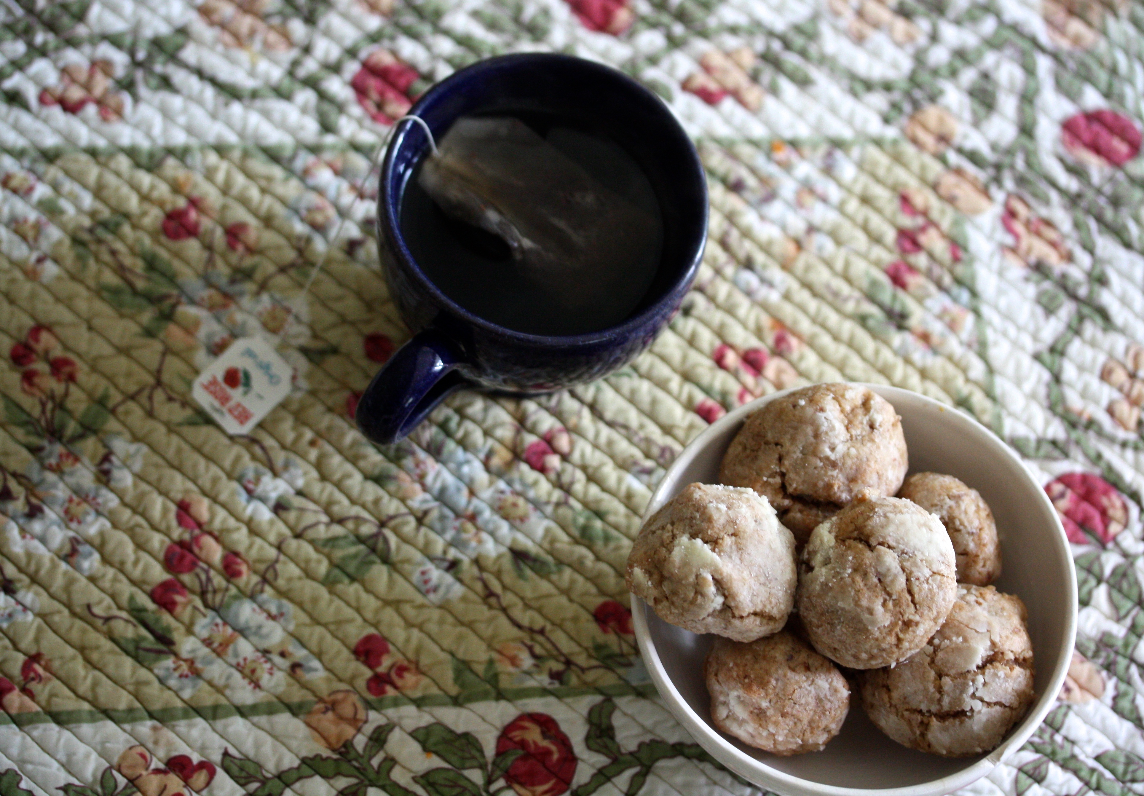 A bowl of ghriba cookies and a cup of tea.