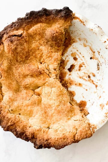 Half of a Gravenstein apple pie in a pie pan.