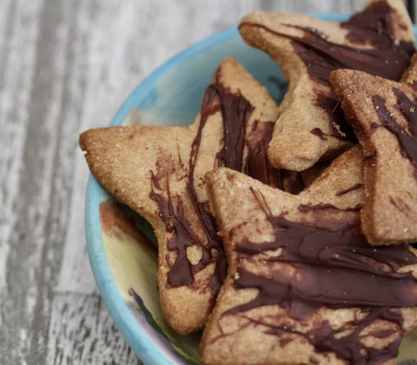 Gluten free shortbread cookies drizzled with chocolate and cut into the shape of stars.