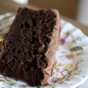 A slice of oat flour chocolate cake on a pretty plate with a fork.