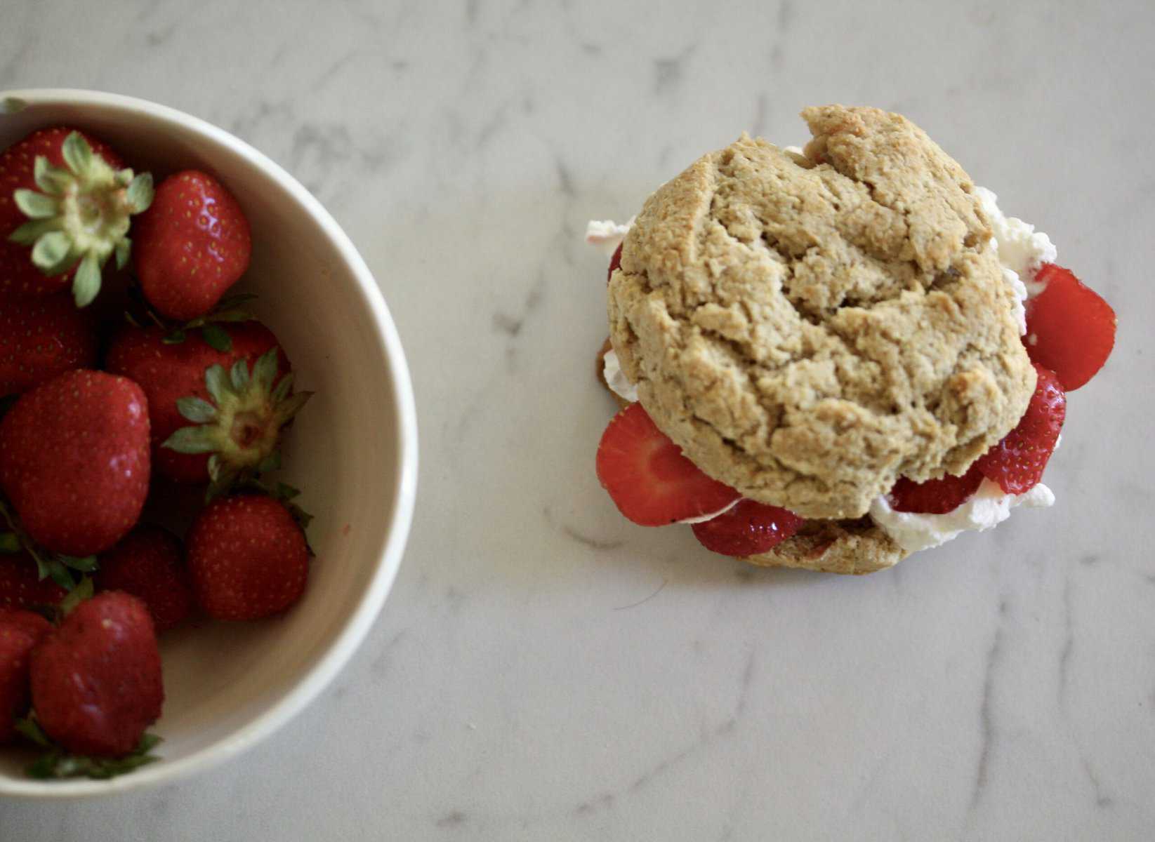 Gluten-free strawberry shortcake and a bowl of strawberries.