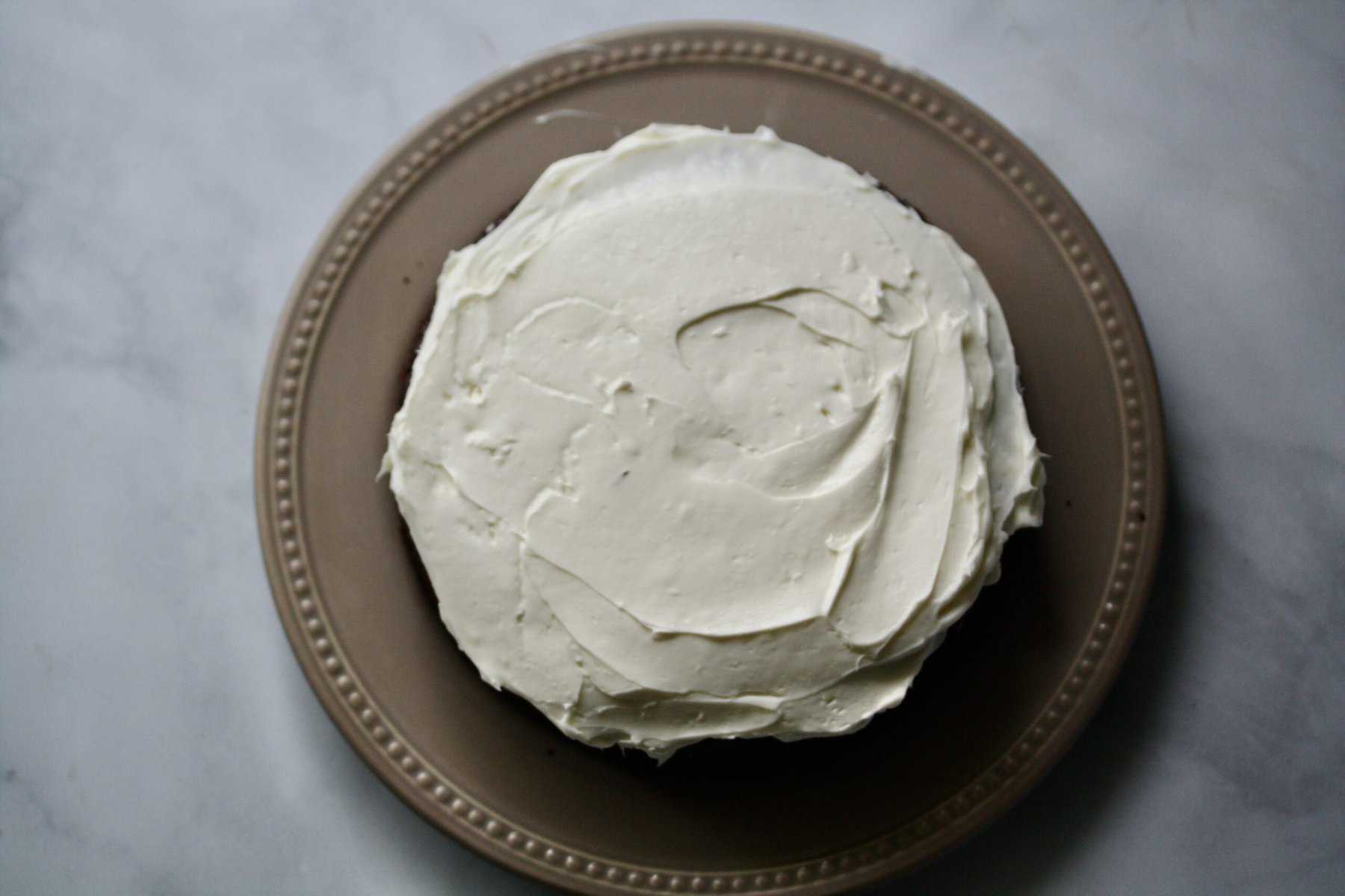 A gluten-free stout cake is iced with cream cheese frosting.