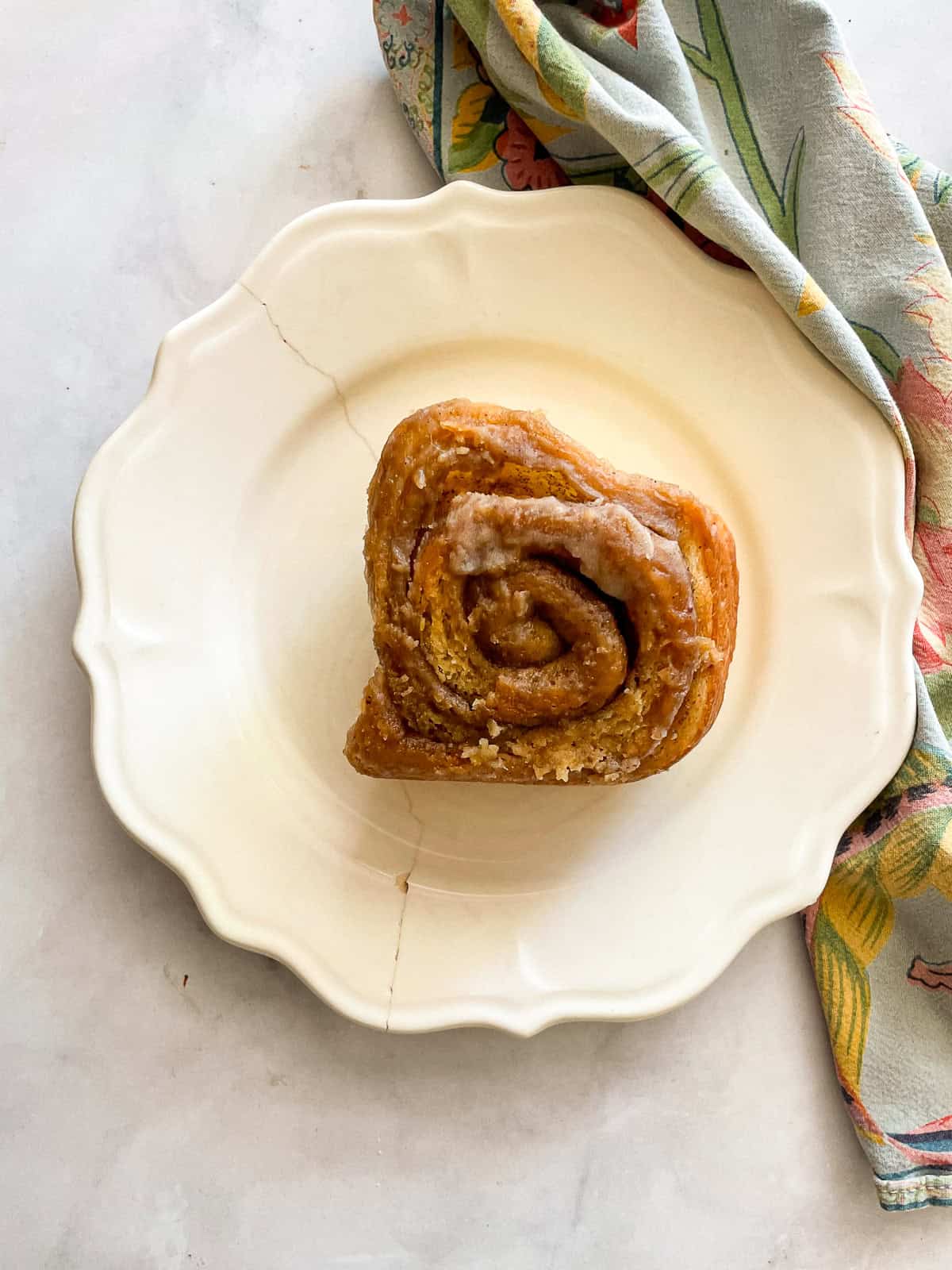 An oat flour cinnamon rolls on a plate on top of a napkin.