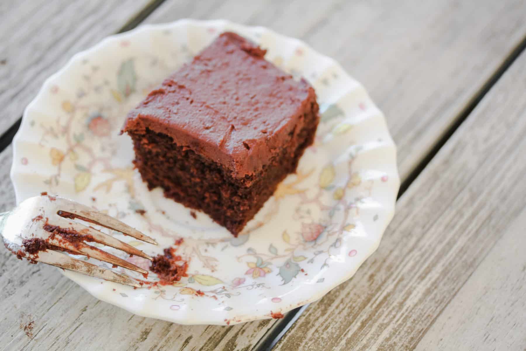 A slice of teff flour chocolate cake on a plate with a fork.