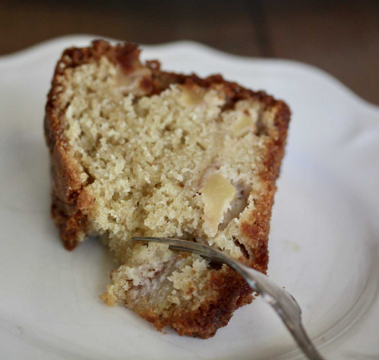 A fork cuts into a piece of pear cake.