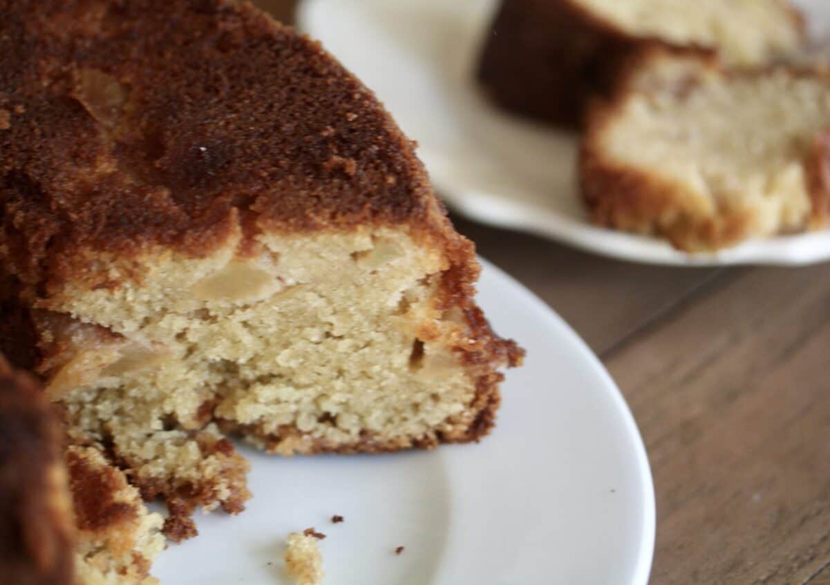Gluten-free pear cake with a plate of cake in the background.