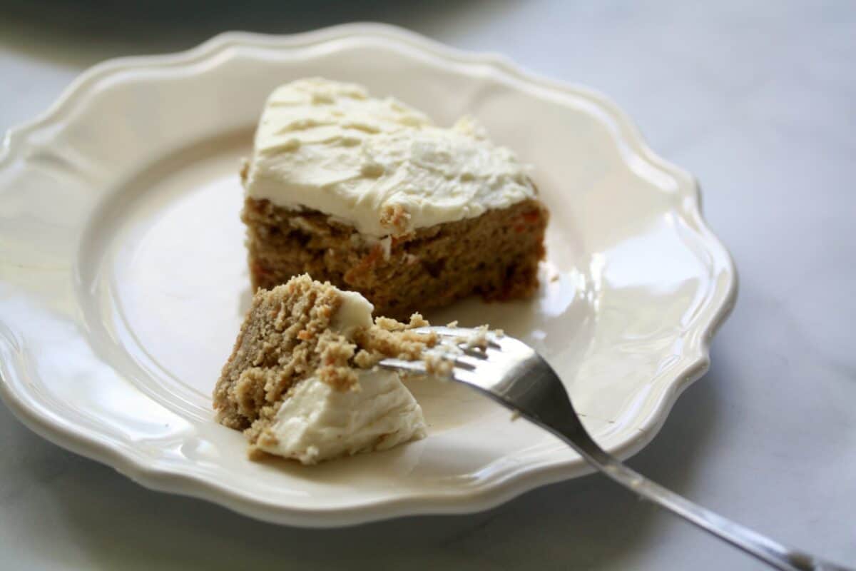 A fork cuts into a piece of gluten-free carrot cake.