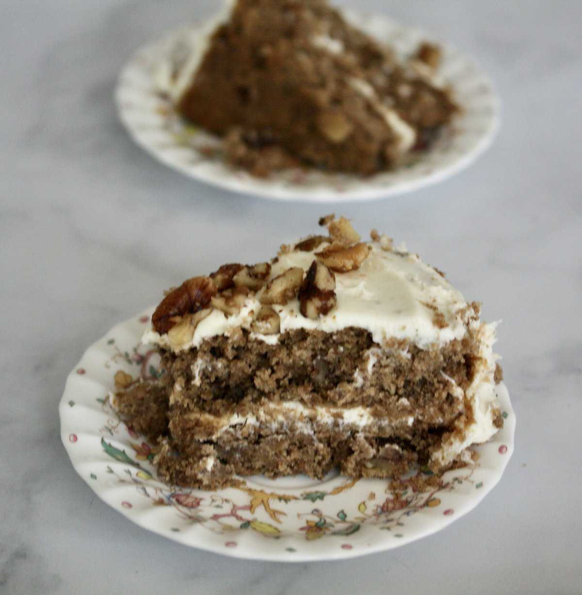 Slices of hummingbird cake on a marble background.