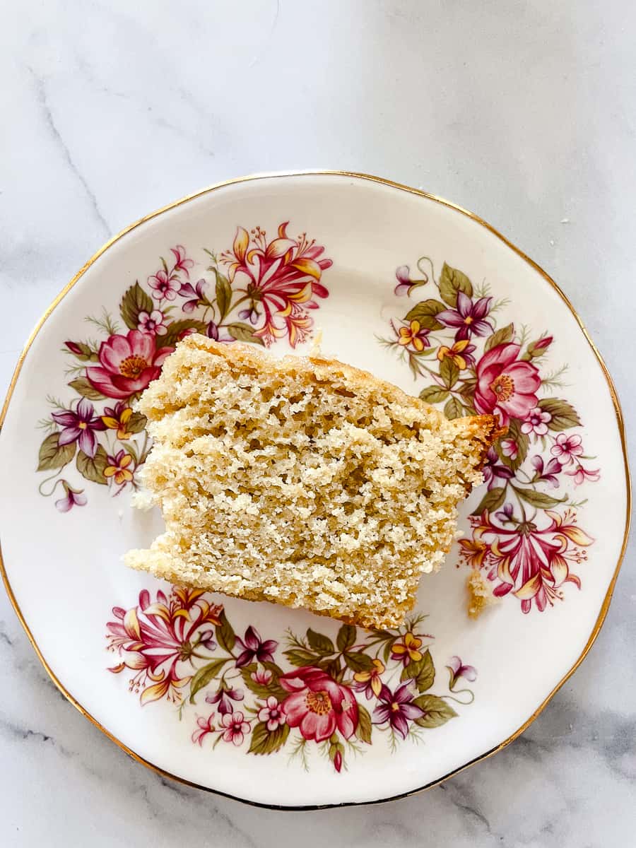 A slice of gluten free lemon cake on a floral plate.