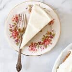 A slice of banana cake with cream cheese frosting