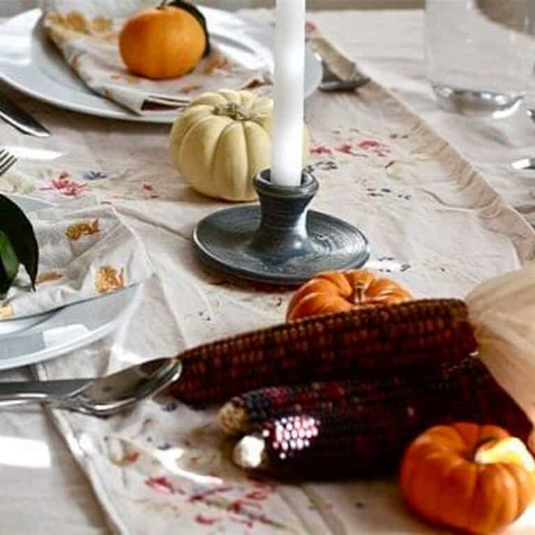 A view of the thanksgiving table with taper candles and mini corn.