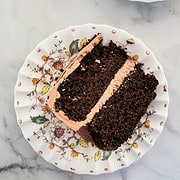A thick slice of gluten free chocolate layer cake on a plate.