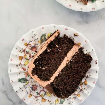 A thick slice of gluten free chocolate layer cake on a plate.