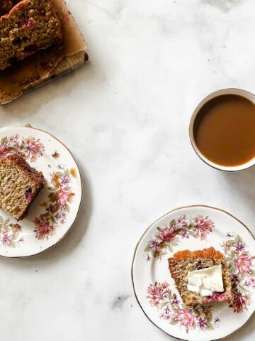 Slices of cranberry orange bread, a cup of tea, and more slices of bread.