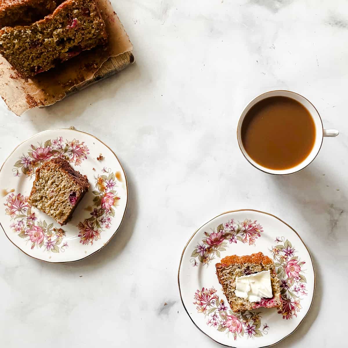 Slices of cranberry orange bread, a cup of tea, and more slices of bread.