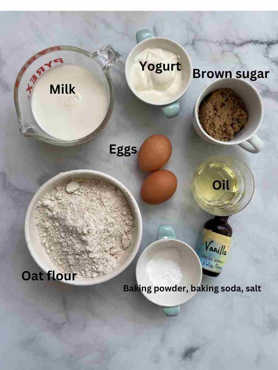 Ingredients needed to make an oat flour cake: oat flour, oil, eggs, brown sugar, baking soda, baking powder, milk, yogurt.