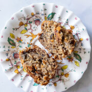 A flowered plate holds two halves of an oat flour banana muffin.
