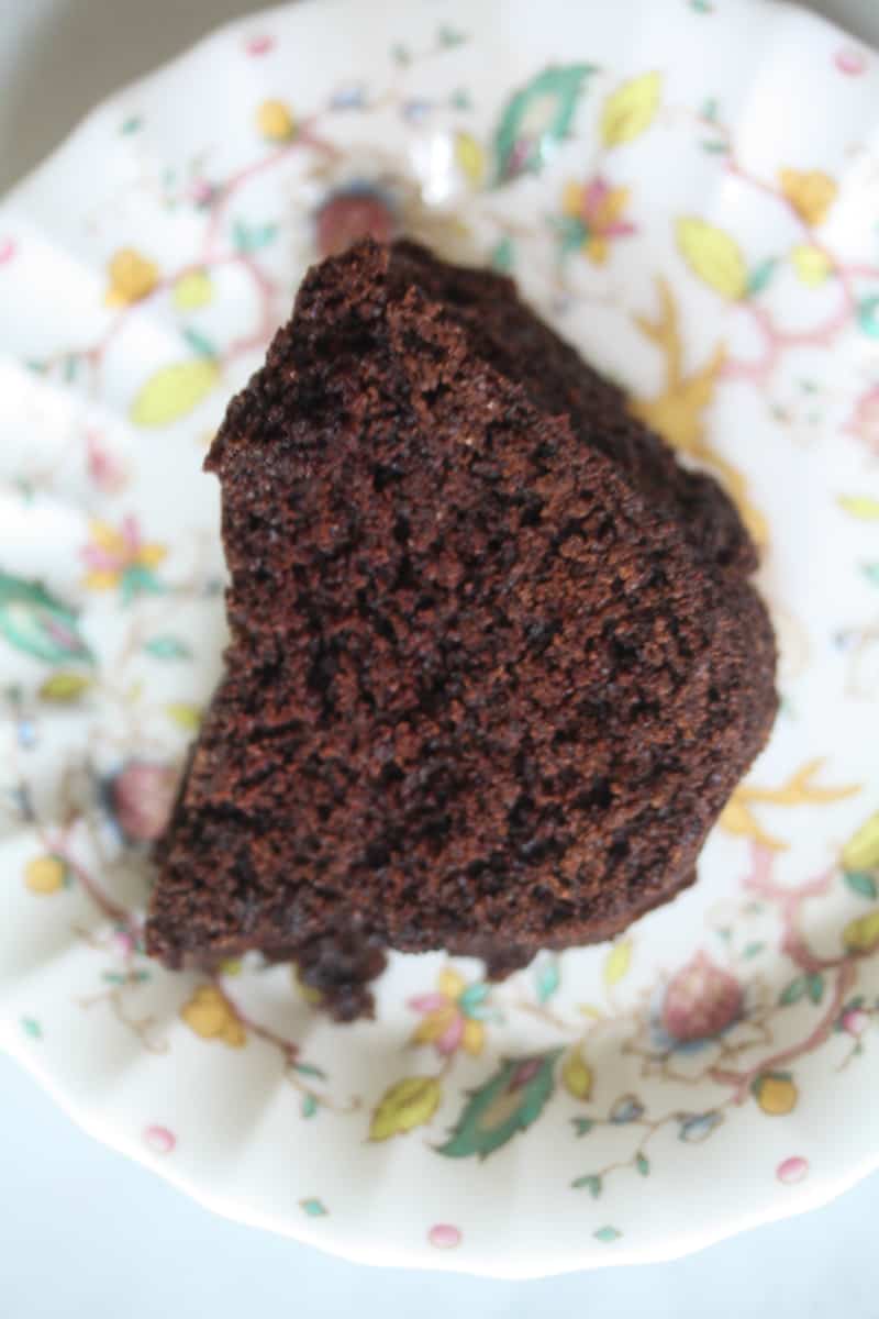 A close up of a slice of vegan chocolate bundt cake on a plate.