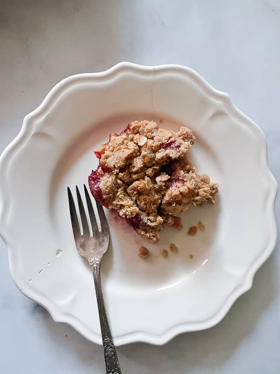 Cranberry apple crisp on a plate with a fork.
