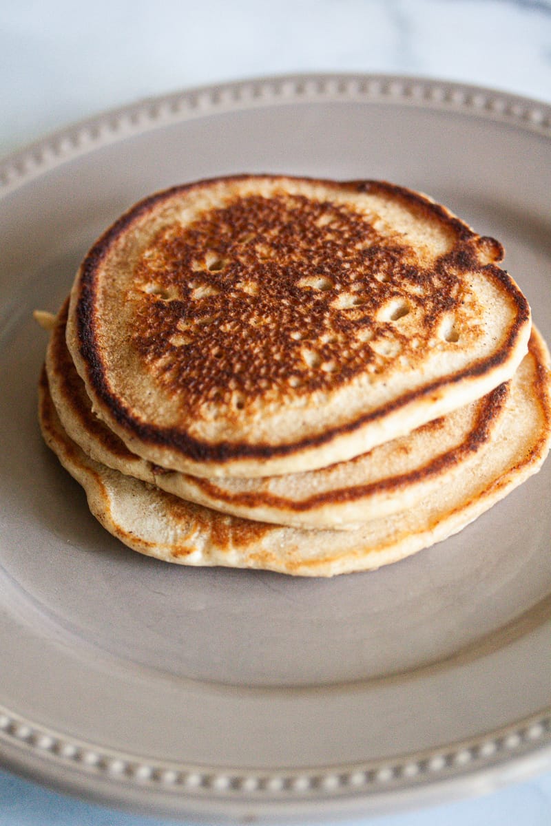 A stack of oat flour pancakes on plate.