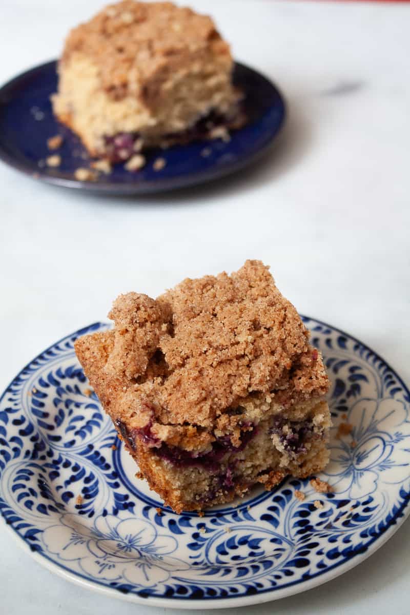 Pieces of blueberry coffee cake are served on blue plates.
