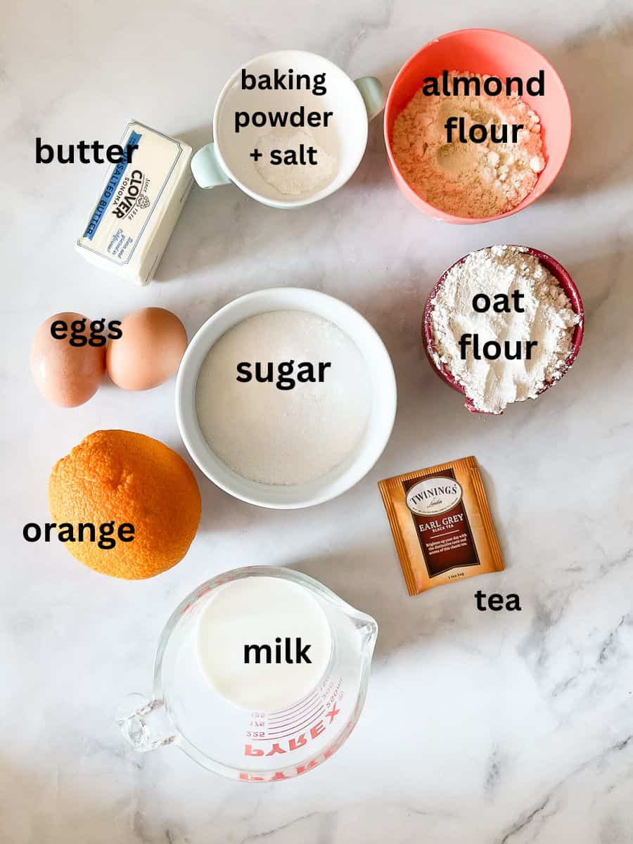 Ingredients for earl grey cake are shown: oat flour, almond flour, eggs, orange, tea, milk, butter, and sugar.