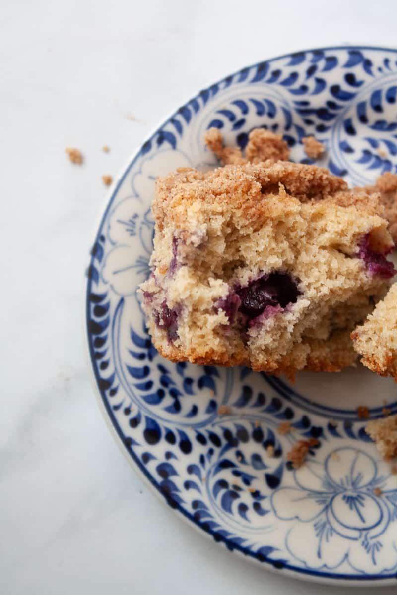 A side view of a piece of blueberry coffee cake.