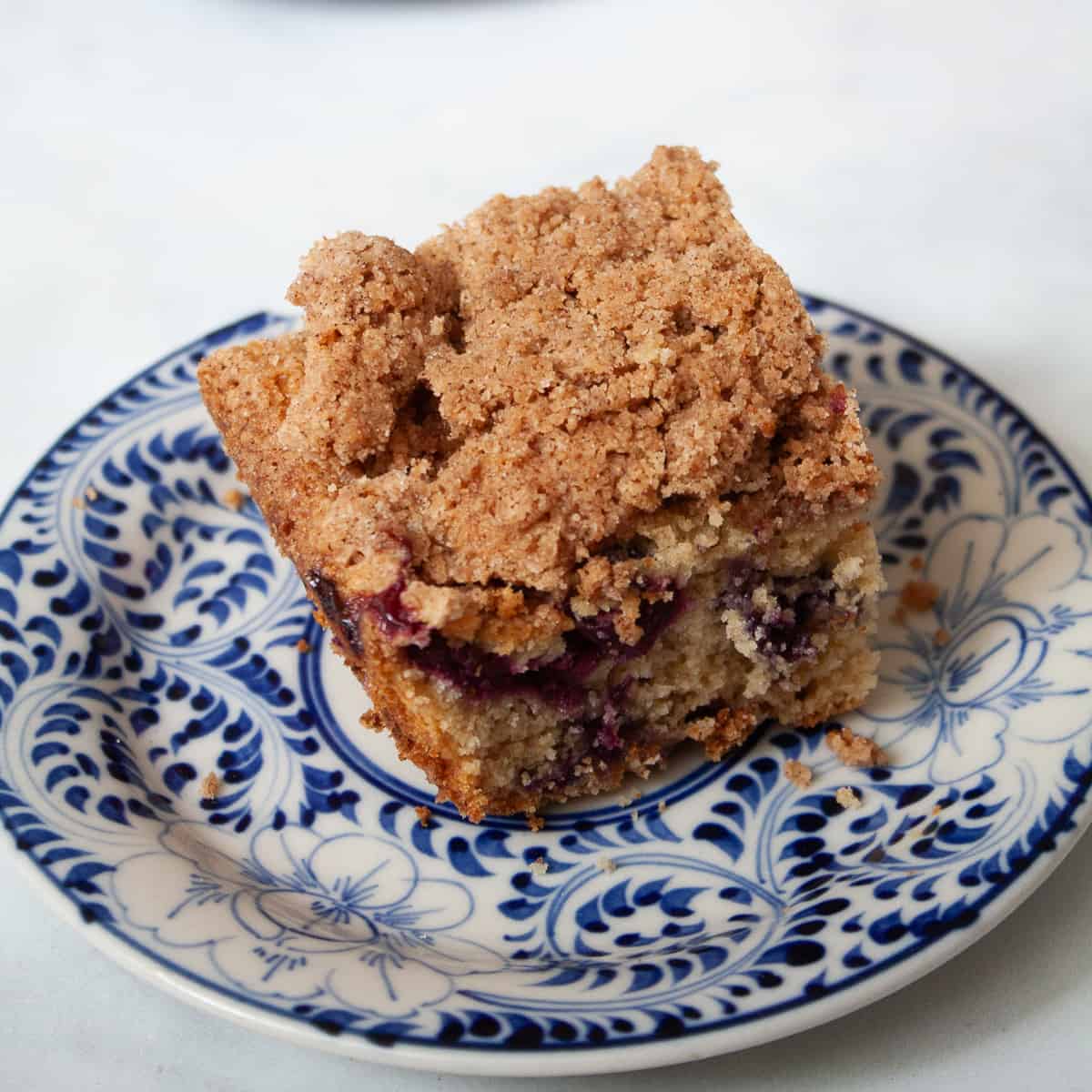A piece of blueberry coffee cake on a plate.