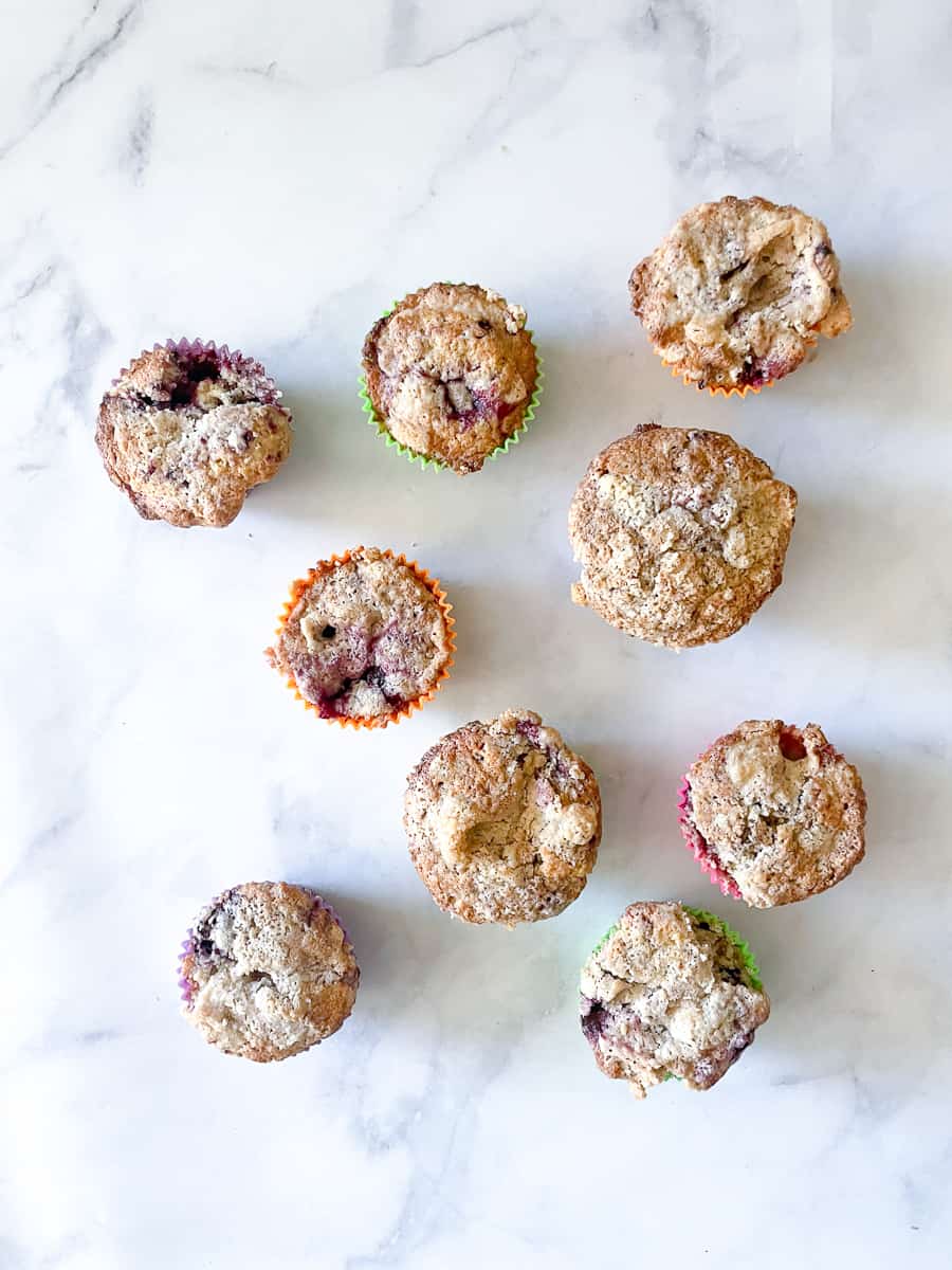 Ten blackberry muffins on a white background.