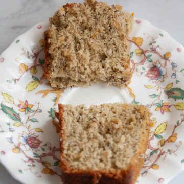 Two halves of a slice of earl grey cake on a plate.