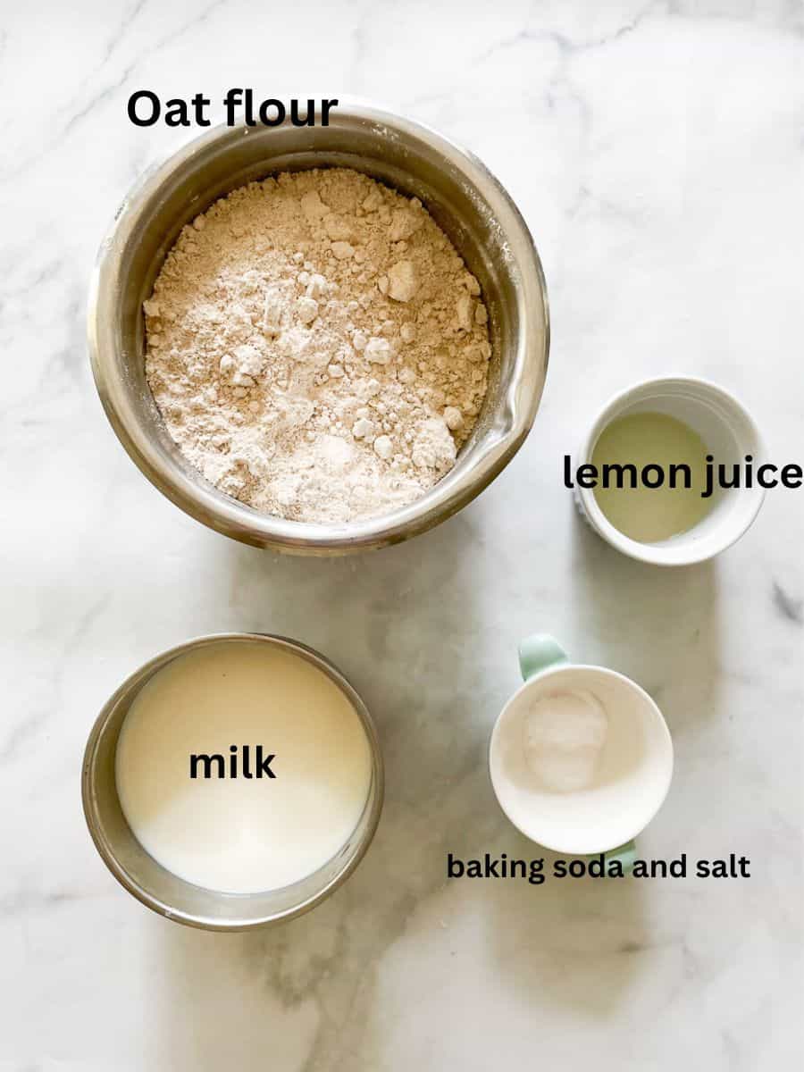 Ingredients needed for gluten free soda bread are shown: oat flour, baking soda, salt, milk, lemon juice.