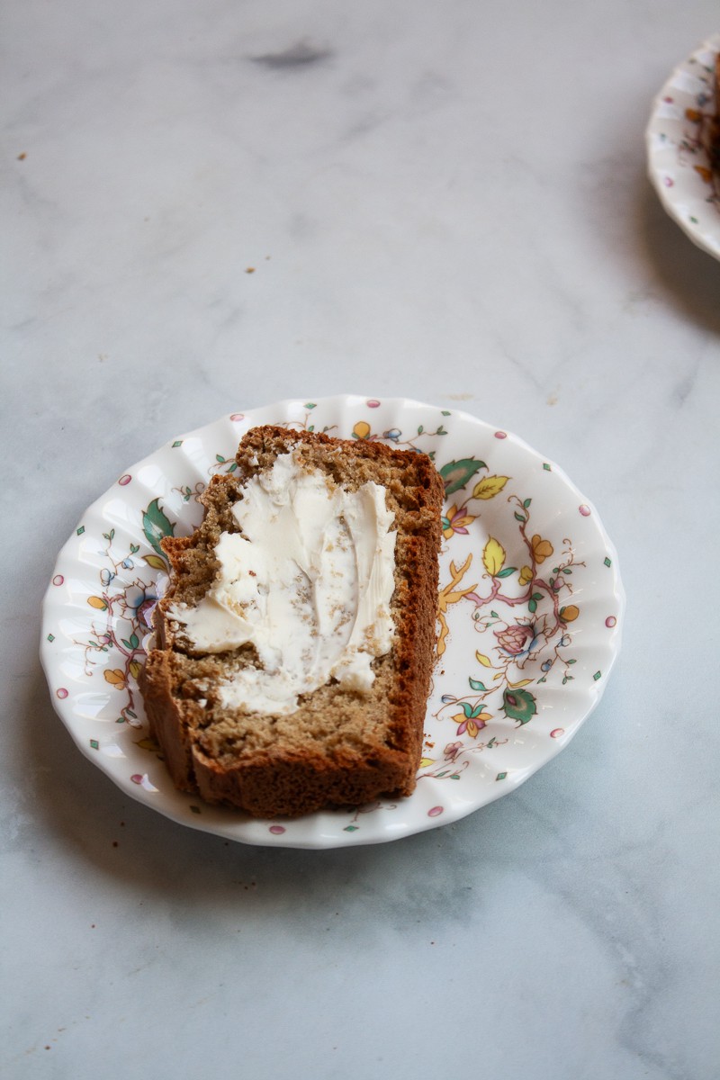 A slice of gluten free Irish soda bread is topped with butter and served on a plate