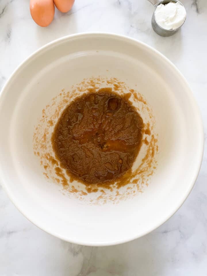 Oil and brown sugar combine in a bowl.