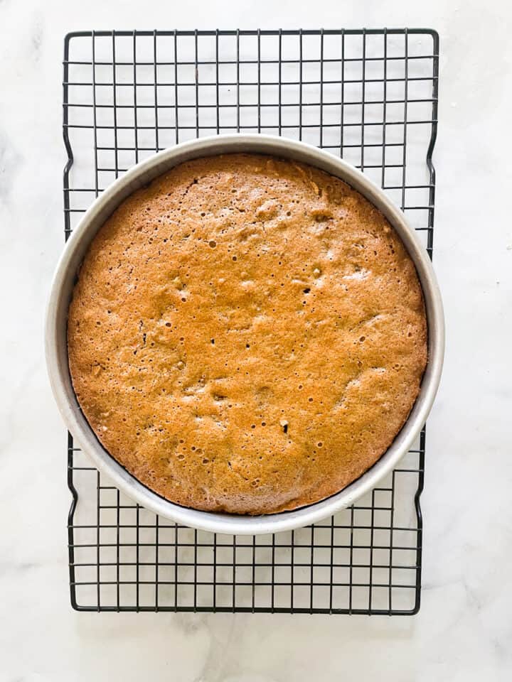The baked gluten free carrot cake cools in the pan on a rack.