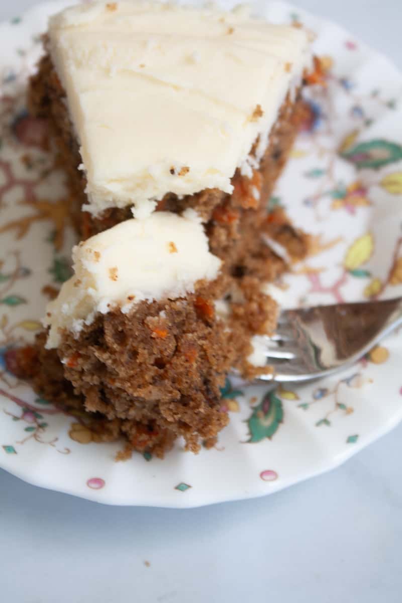A fork cuts into a piece of gluten free carrot cake to show the crumb.