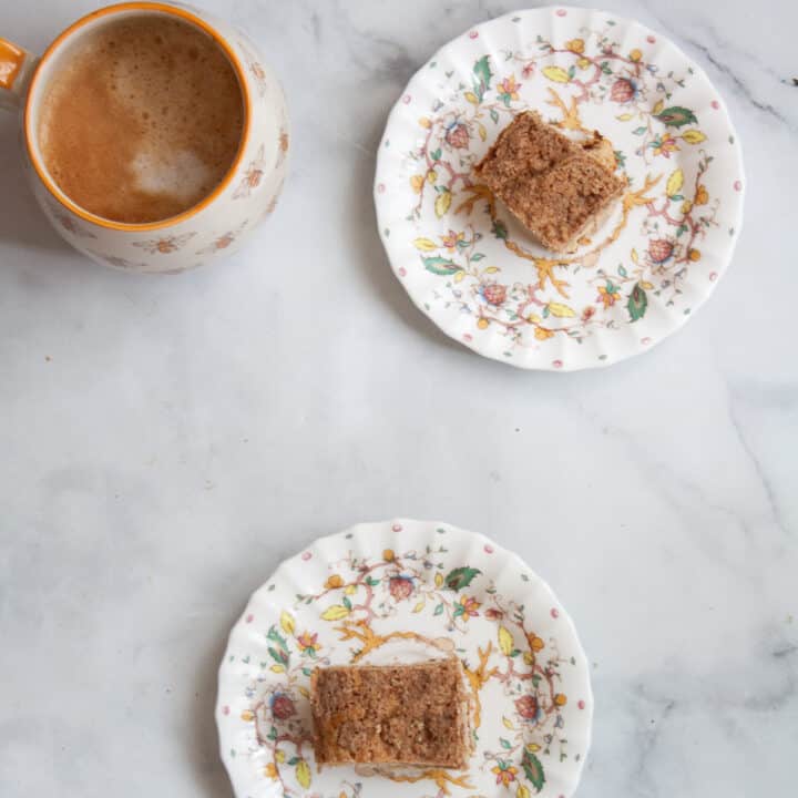 Plates of gluten free coffee cake with a cup holding a latte.