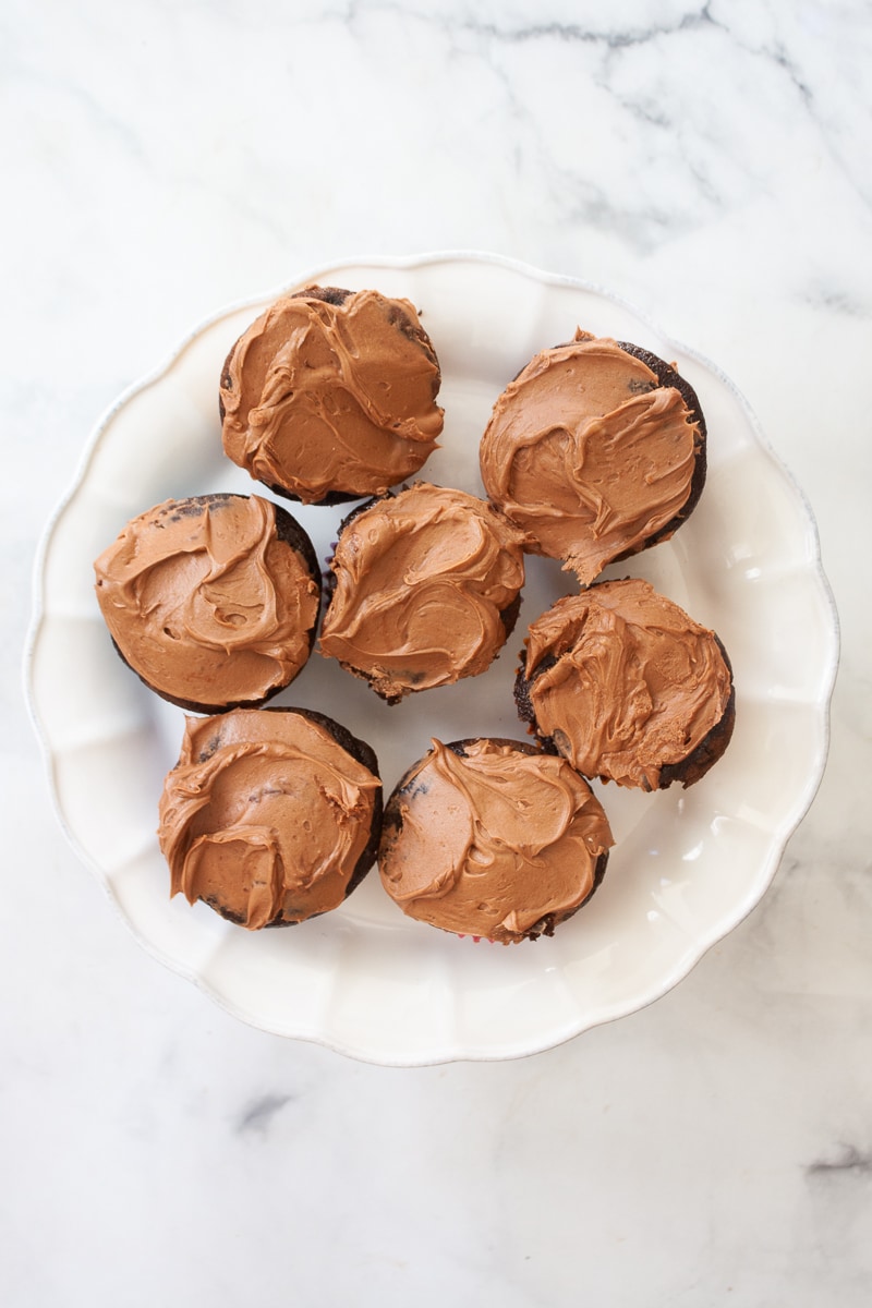 A cake stand holds gluten free chocolate cupcakes.