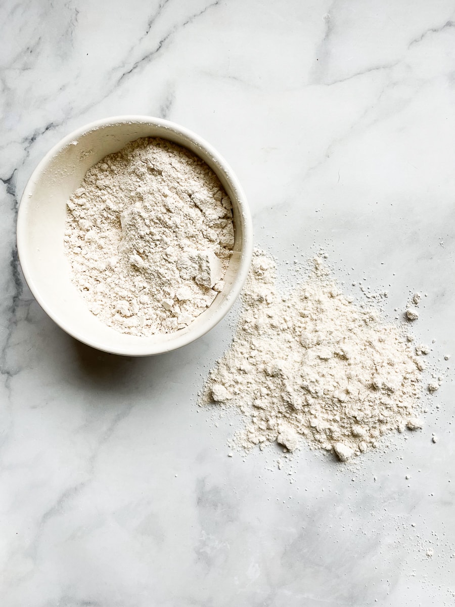A bowl of homemade gluten free flour blend with a little bit next to it.