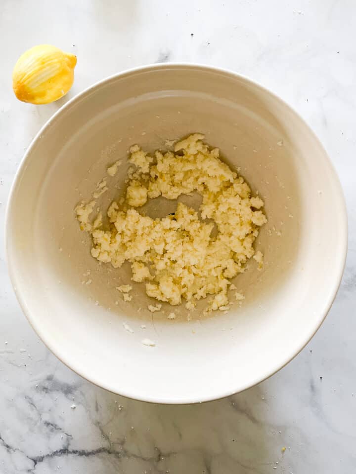 Lemon zest, butter, and sugar are creamed in a bowl.