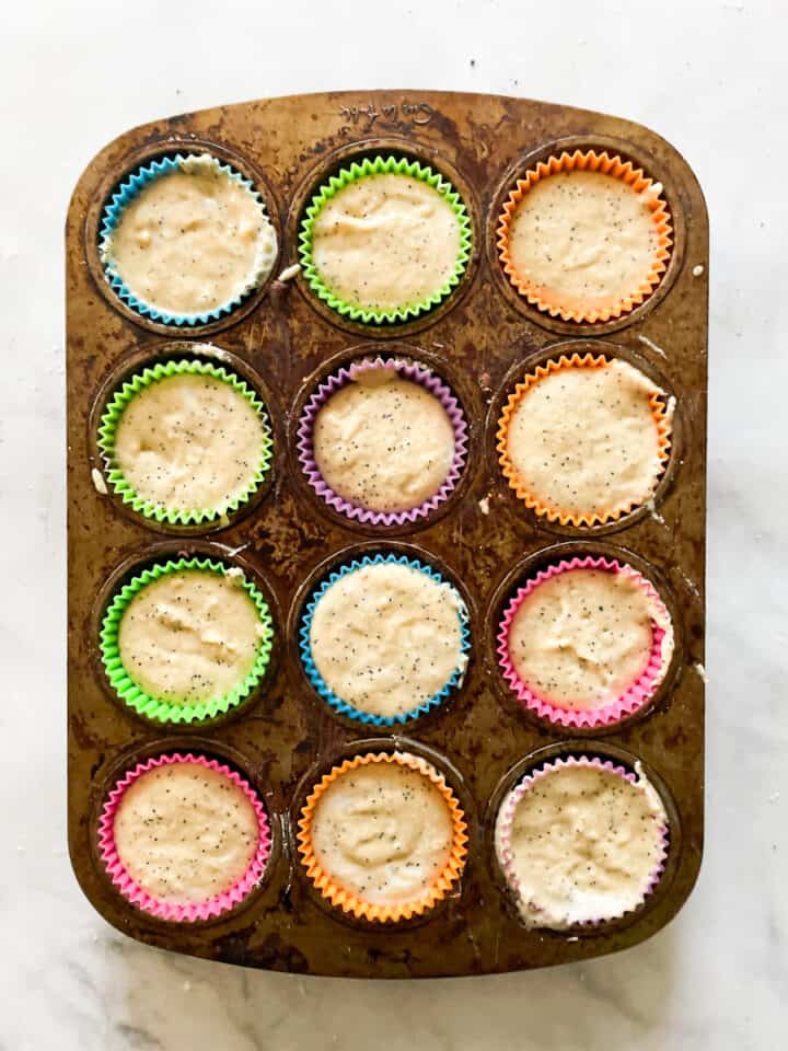 Lemon poppyseed muffin batter portioned into a muffin tin.