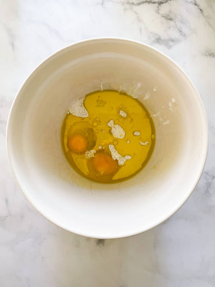 Eggs, oil, and buttermilk are combined in a bowl.