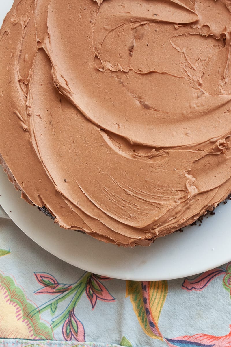 Chocolate icing is shown close up on a chocolate cake.