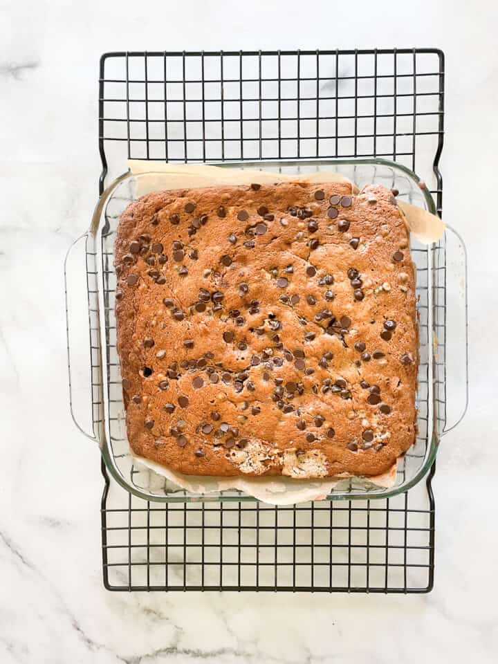 The baked gluten free banana chocolate chip cake cools on a rack.