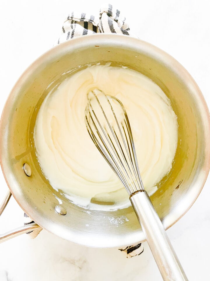 The roux is whisked in a pot.